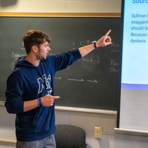 Psychology major pointing to a presentation in class