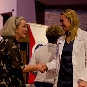 woman shaking hand with nurses jacket