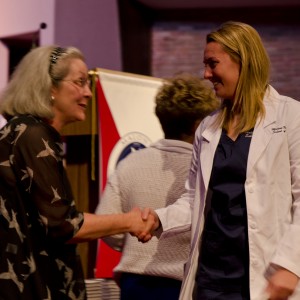 woman shaking hand with nurses jacket