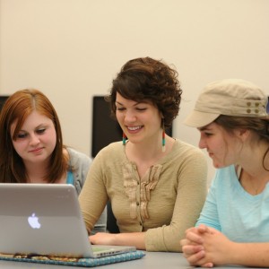 three women looking at a laptop