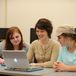 three women looking at laptop