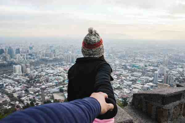 woman looking aver a city, holding a man's hand