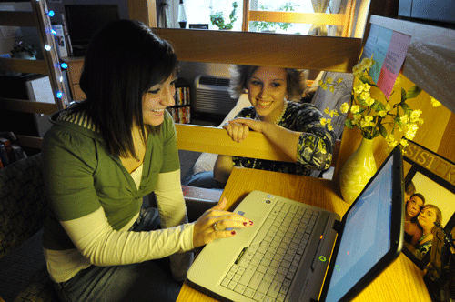 two women in dorm with laptop